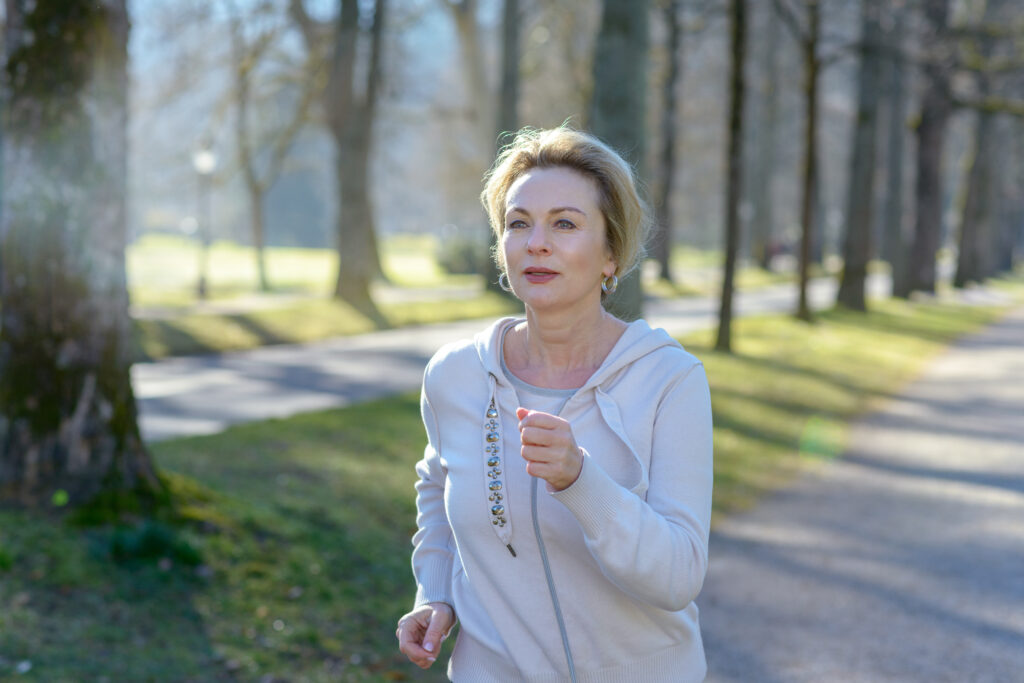 Smiling healthy happy fit senior woman jogging
